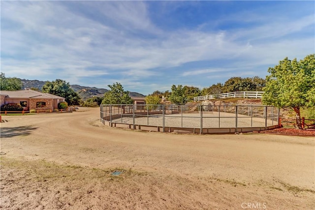 view of home's community featuring a rural view, fence, and a mountain view