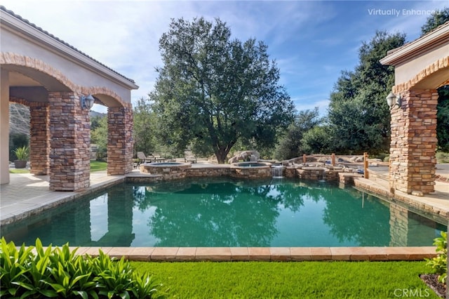 outdoor pool with a patio and an in ground hot tub