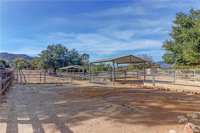 view of yard with a rural view, an outdoor structure, an exterior structure, and a mountain view