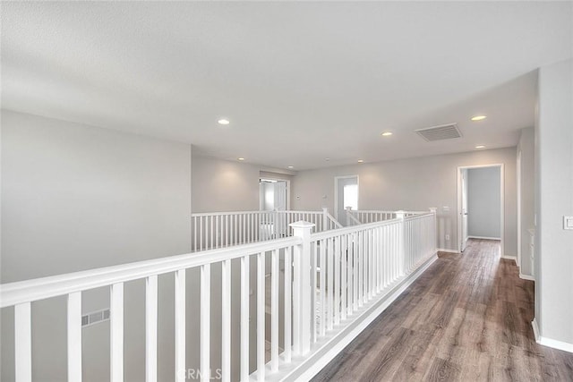 hallway with baseboards, visible vents, wood finished floors, and recessed lighting