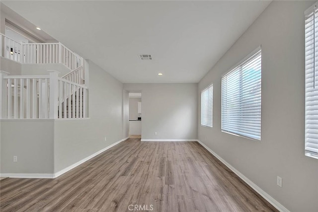 empty room featuring recessed lighting, wood finished floors, visible vents, and baseboards