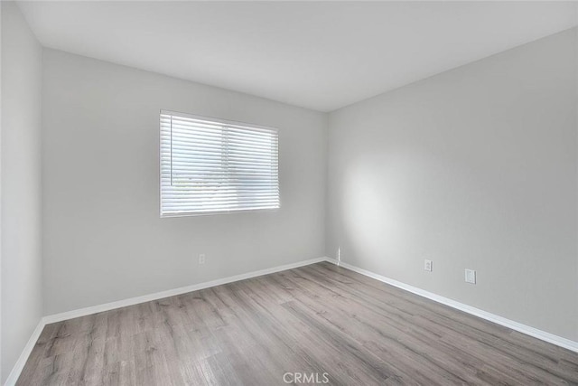 empty room featuring baseboards and wood finished floors