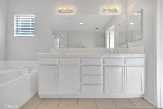 bathroom featuring a sink, double vanity, a stall shower, and a garden tub