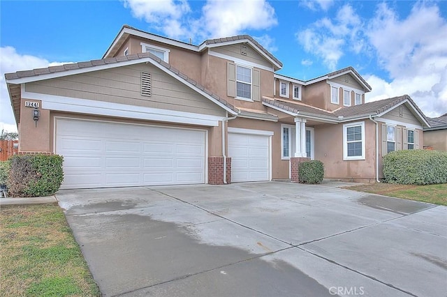 view of front of property with brick siding, driveway, an attached garage, and stucco siding