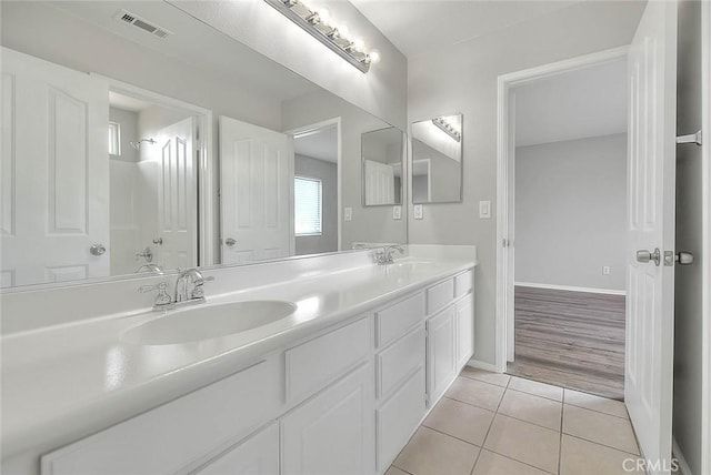 full bathroom featuring double vanity, visible vents, a sink, and tile patterned floors