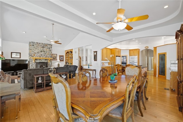 848 Burlando Rd, Kernville, CA 93238 - dining area with a ceiling fan, a stone fireplace, light wood-style floors, arched walkways, and lofted ceiling