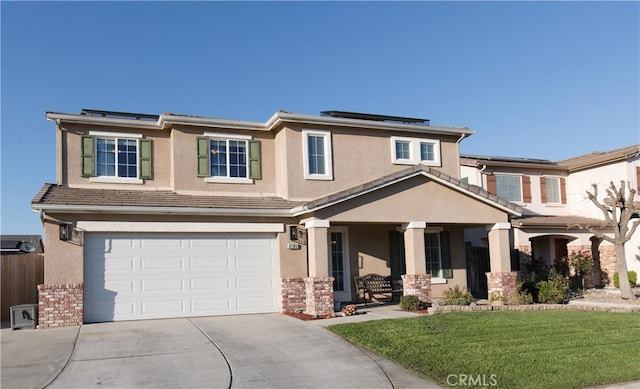 view of front of home featuring concrete driveway, solar panels, stucco siding, an attached garage, and a front yard