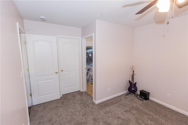 unfurnished bedroom featuring carpet, a ceiling fan, and baseboards