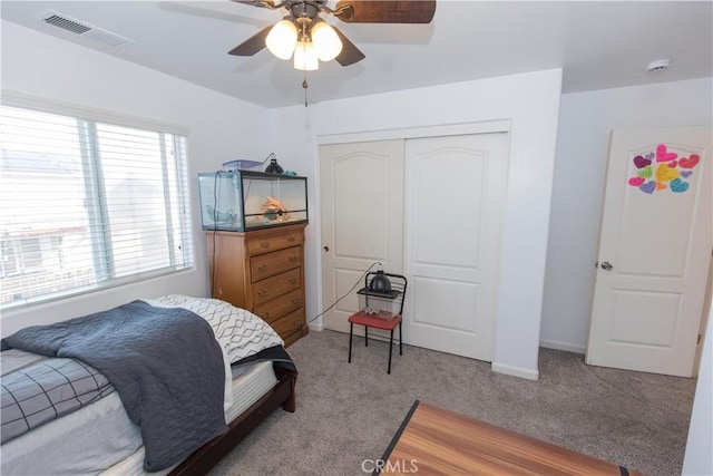 carpeted bedroom with a closet, visible vents, ceiling fan, and baseboards