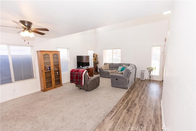 living area with vaulted ceiling, a ceiling fan, and baseboards