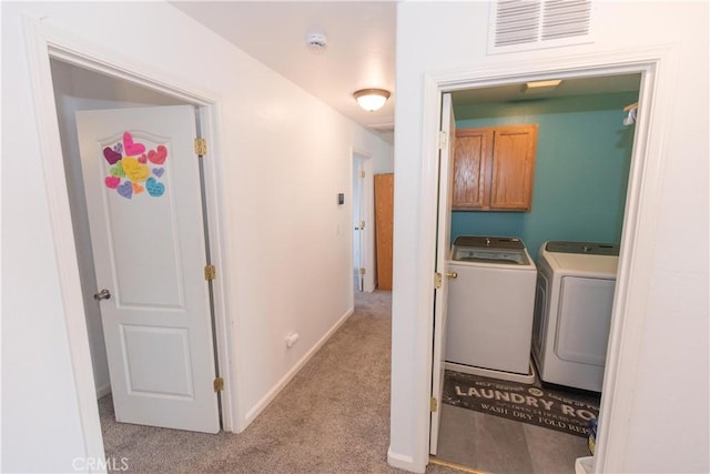 laundry area with washing machine and clothes dryer, visible vents, cabinet space, light carpet, and baseboards