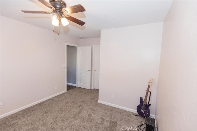 unfurnished room featuring carpet, baseboards, and a ceiling fan