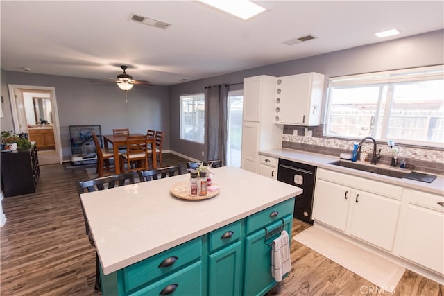 kitchen featuring white cabinetry, black dishwasher, visible vents, and a sink