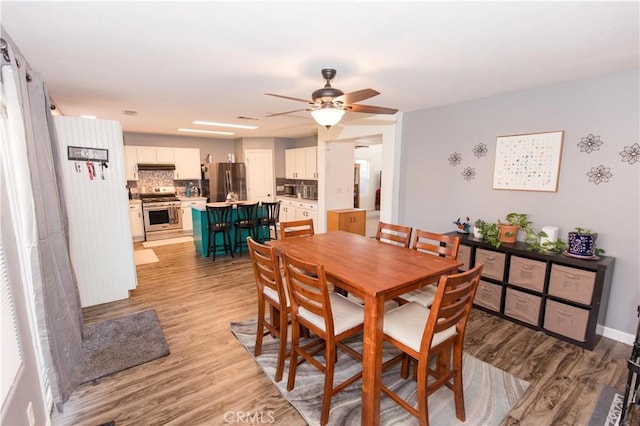 dining space with a ceiling fan and light wood-style flooring