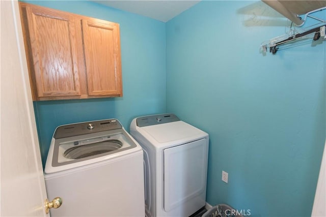 laundry area featuring separate washer and dryer and cabinet space