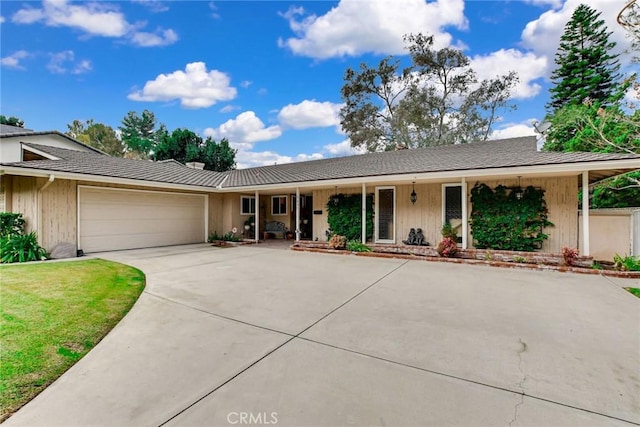 ranch-style house with a porch, driveway, and an attached garage