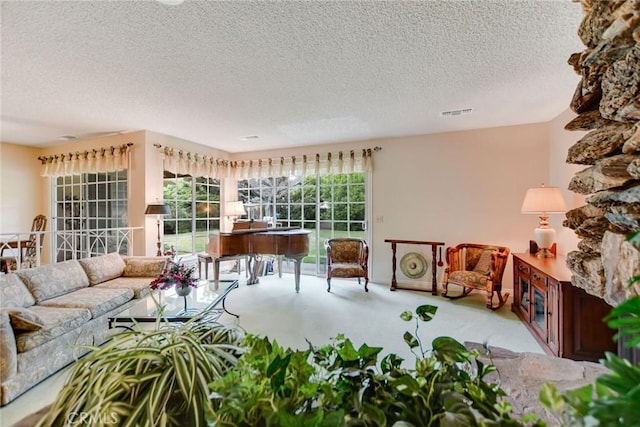 living room with carpet floors, visible vents, and a textured ceiling