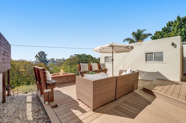 deck with an outdoor living space with a fire pit