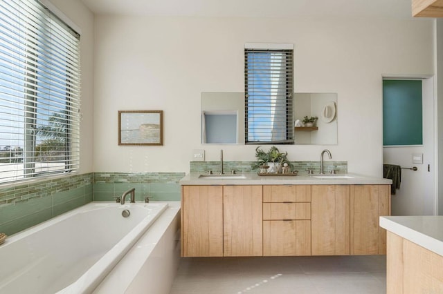 full bath with tile patterned floors, a garden tub, a sink, and double vanity