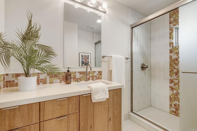 full bath featuring tasteful backsplash, a shower stall, and vanity