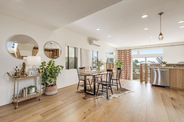 dining space with recessed lighting, a wall unit AC, and light wood-style flooring