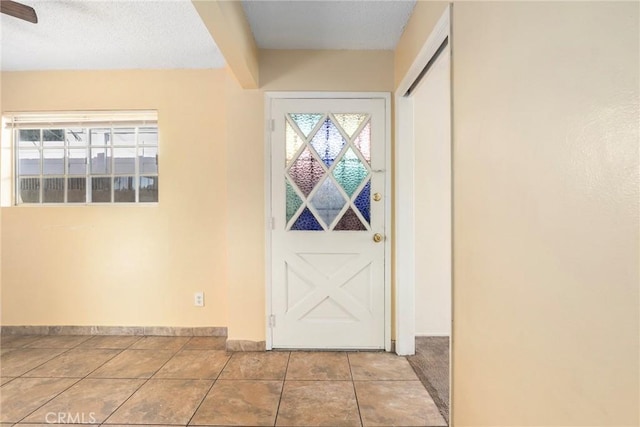 interior space featuring plenty of natural light, baseboards, and tile patterned flooring