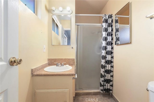 bathroom with curtained shower, vanity, toilet, and tile patterned floors