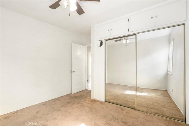 unfurnished bedroom with a closet, a ceiling fan, and light colored carpet