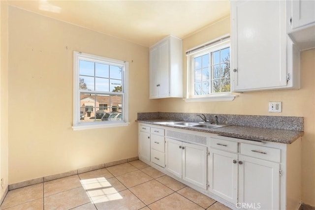 kitchen featuring light tile patterned floors and white cabinets