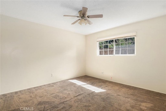 carpeted spare room with a ceiling fan