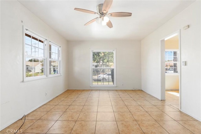 empty room featuring a ceiling fan and light tile patterned flooring