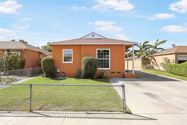 view of front of house with driveway, a front lawn, fence private yard, and stucco siding