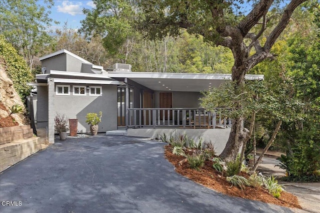 mid-century inspired home featuring covered porch and stucco siding