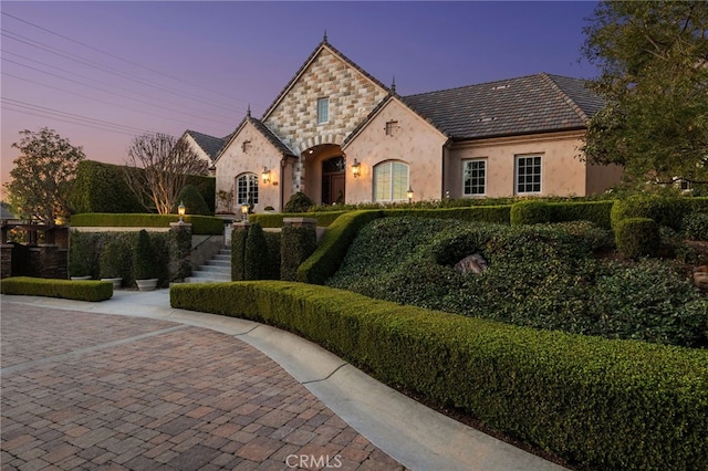 french country style house with stone siding