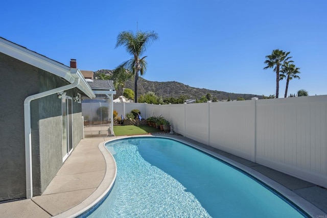 view of pool with a mountain view, a fenced backyard, and a fenced in pool