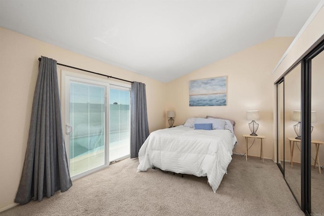 bedroom with access to exterior, lofted ceiling, and carpet floors