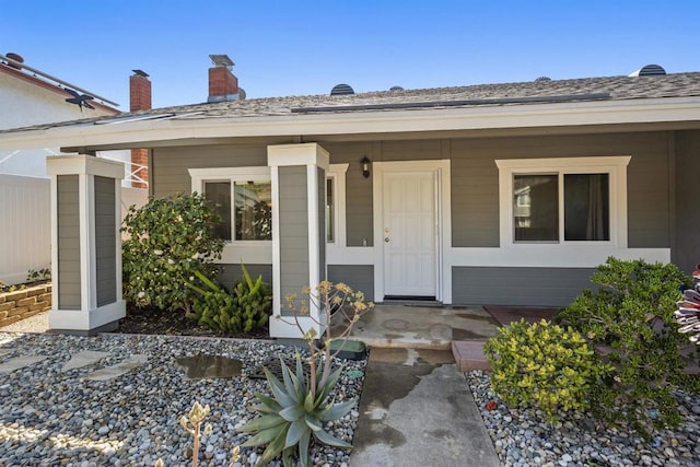 property entrance featuring a porch and a shingled roof