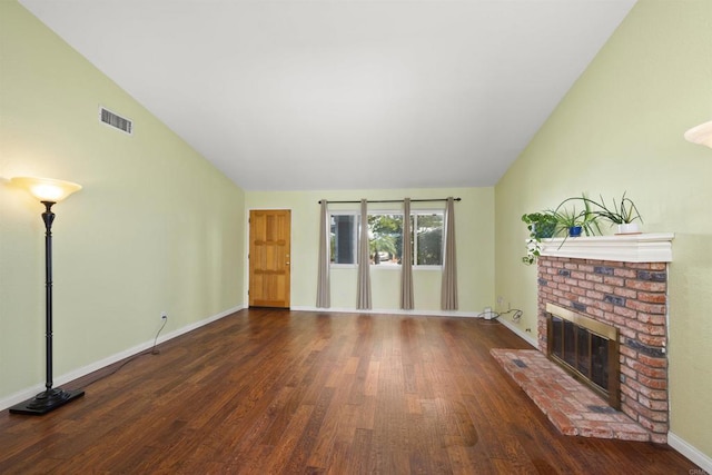 unfurnished living room featuring baseboards, visible vents, wood finished floors, a brick fireplace, and high vaulted ceiling