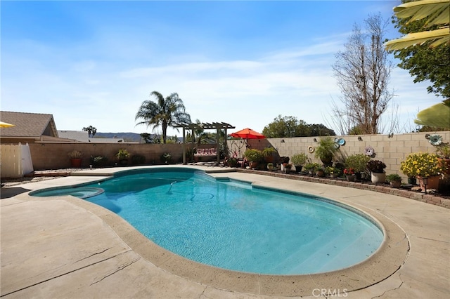 view of swimming pool featuring a patio area, a fenced backyard, and a pool with connected hot tub