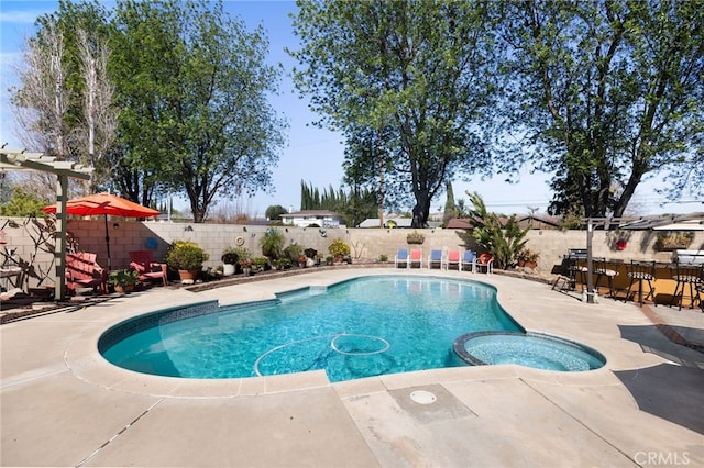 view of pool with a pool with connected hot tub, a patio area, and a fenced backyard