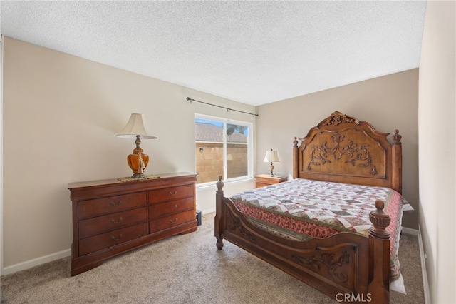 carpeted bedroom featuring baseboards and a textured ceiling