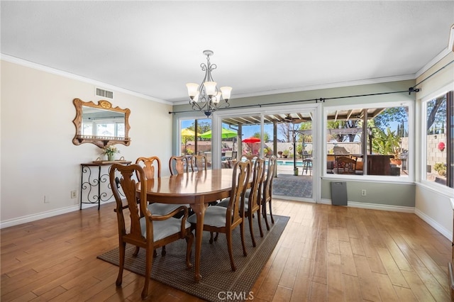 dining space featuring a wealth of natural light, visible vents, crown molding, and hardwood / wood-style floors