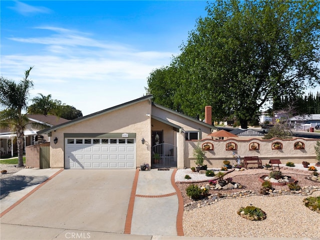 mid-century modern home with stucco siding, concrete driveway, a gate, fence, and a garage