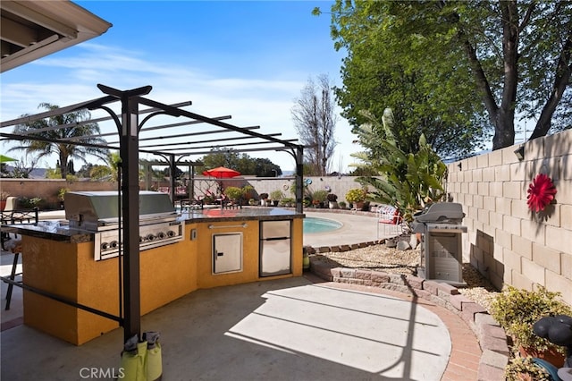 view of patio with exterior kitchen, a fenced backyard, and a grill