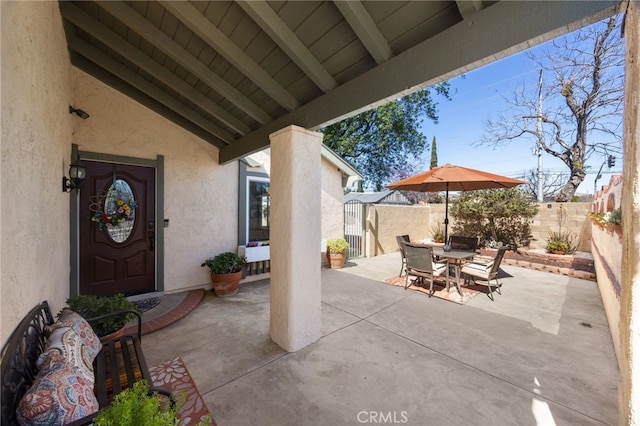 view of patio / terrace featuring a fenced backyard, outdoor dining area, and an outbuilding