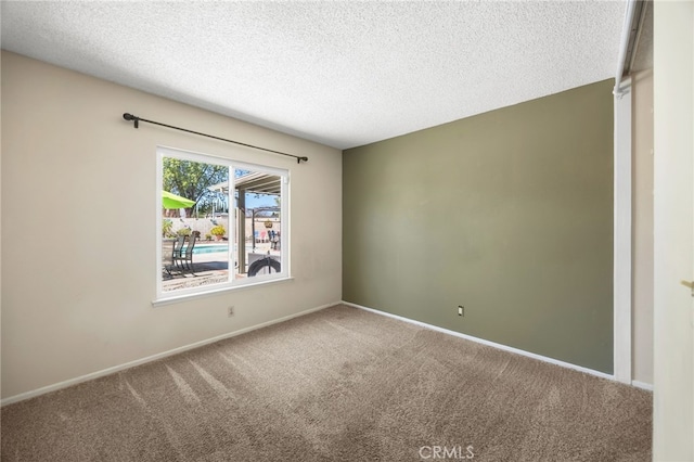 unfurnished room featuring carpet, a textured ceiling, and baseboards