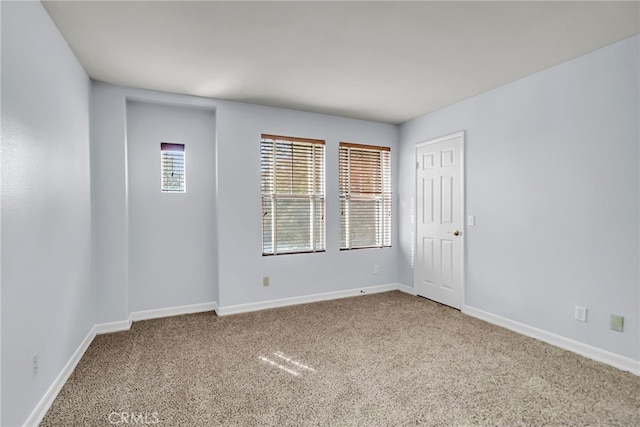 empty room with carpet floors and baseboards