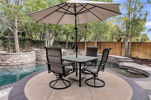 view of patio with fence, a fenced in pool, and outdoor dining space