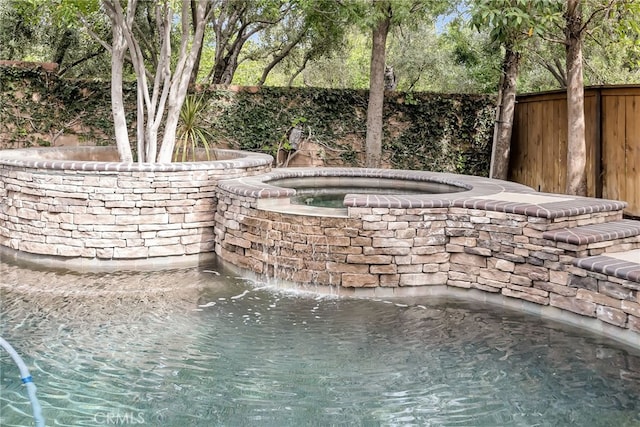 exterior space featuring a jacuzzi and a fenced backyard