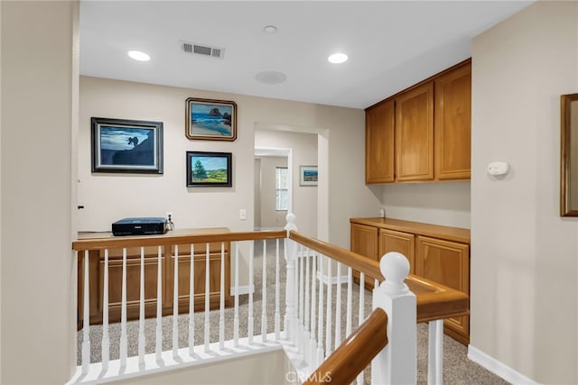 hallway featuring recessed lighting, visible vents, baseboards, and an upstairs landing